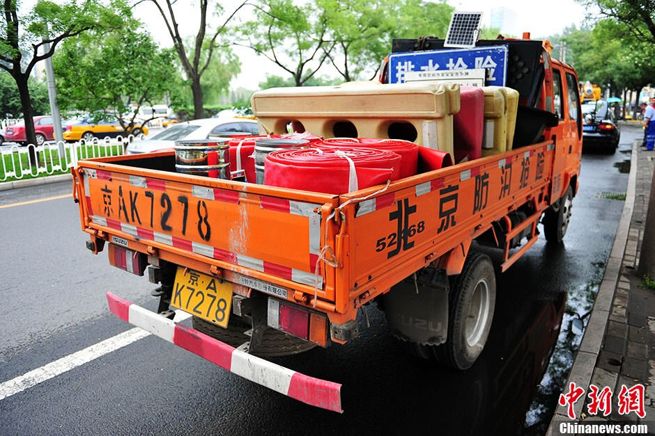 Emergency rescue vehicles, such as the highly-effective drainage vehicles and electricity-generating vehicles are stationed near the Guangqumen Bridge in Beijing, capital of China, on July 9. The capital city's flood control office together with other government authorities has designed emergency plans to prevent heavy rain-induced accidents as the city enters its flood season. (Photo from Chinanews.com/Translated by Zhang Junmian) (Source: China.org.cn)