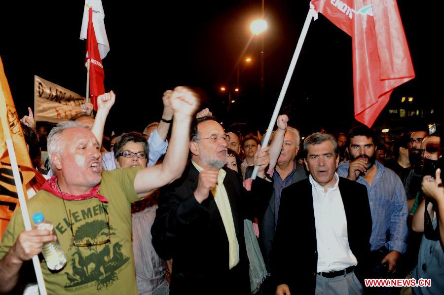 Greek leftist deputies participate in anti-austerity demonstration outside the Greek parliament in Athens on Wednesday, July 17, 2013. Greek parliament approved early on Thursday a new austerity and reform bill which contains mass job cuts in the public sector in a key step to unlock further international bailout aid to the debt-laden country. (Xinhua) 