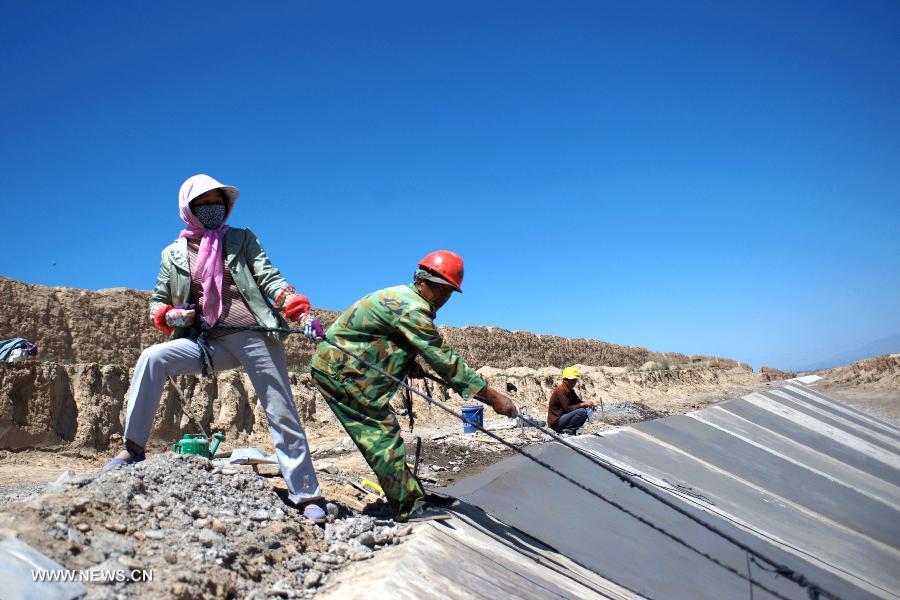 Workers work at the construction site for protecting the Great Wall in Shandan County, northwest China's Gansu Province, July 19, 2013. This year, the local authorities has allocated more than 30 million yuan (about 4.89 million U.S. dollars) for the protection of the Great Wall in Shandan County, which was built in the Ming Dynasty (1368-1644) and has a length of 88 kilometers. (Xinhua/Chen Bin)