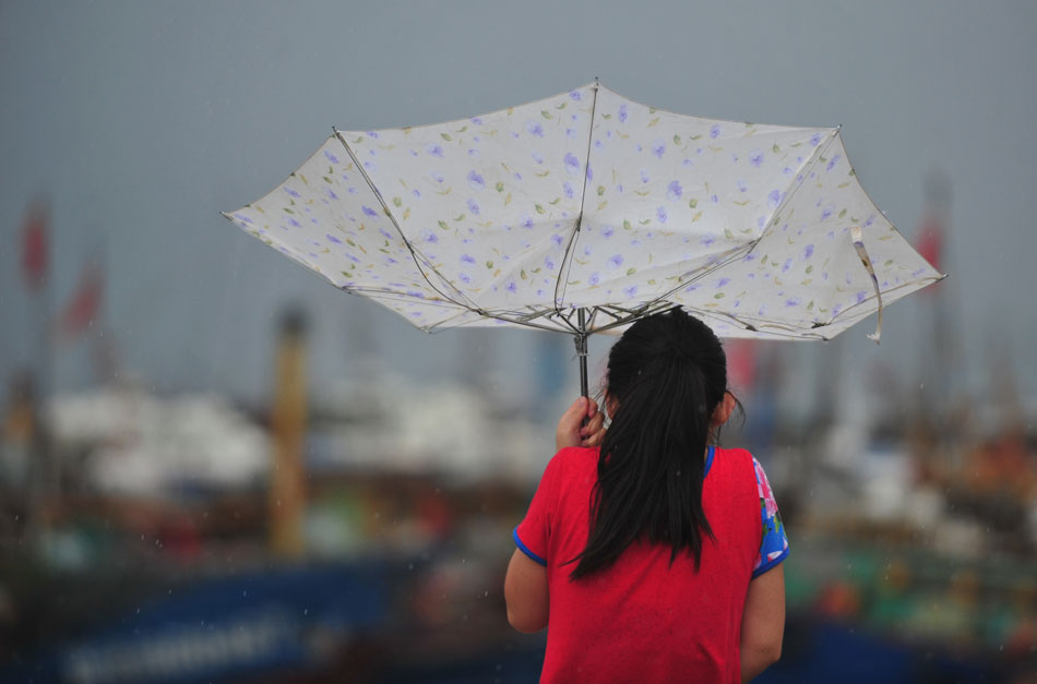 A journalist braves the rainstorm in a dock of Luoyuanwan of Fujian province. Typhoon Soulik made a landfall in Fujian province on the Chinese mainland. (Xinhua/Wei Peiquan)