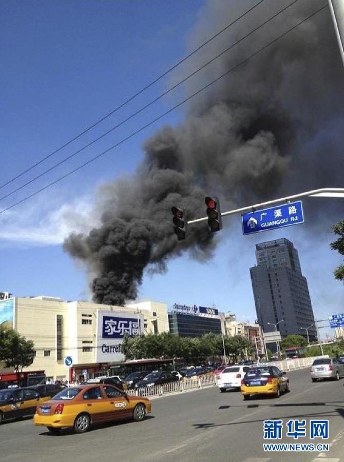 Photo taken by mobile phone on July 24, 2013 shows the smoke from a Carrefour outlet building in Chaoyang District of Beijing, capital of China. Fire broke out at the supermarket around 3:10 p.m. on Wednesday. (Xinhua)