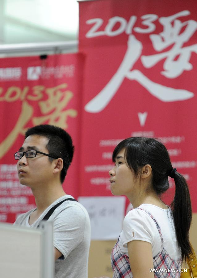 Photo taken on June 5, 2013 shows jobs seeker reading job information in Hangzhou, capital of east China's Zhejiang Province. Figures from the Ministry of Human Resources and Social Security on July 25 showed that the urban employment increased by 7.25 million in China in the first six months of the year, an increase of 310,000 year on year. The registered urban unemployment rate stood at 4.1 percent at the end of the second quarter. (Xinhua/Ju Huanzong)