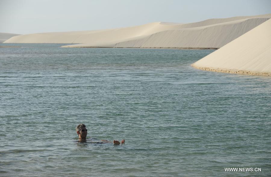 People visit Lencois Maranhenses National Park located in northeast Brazil's Maranhao state, July 28, 2013. At the end of rain season every year, crystal clear lagoons form in the desert here.(Xinhua/Weng Xinyang)