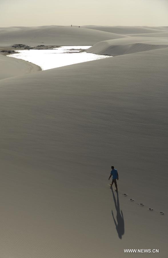 A tourist visits Lencois Maranhenses National Park located in northeast Brazil's Maranhao state, July 28, 2013. At the end of rain season every year, crystal clear lagoons form in the desert here.(Xinhua/Weng Xinyang)